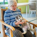 Seniorin mit Hundewelpen